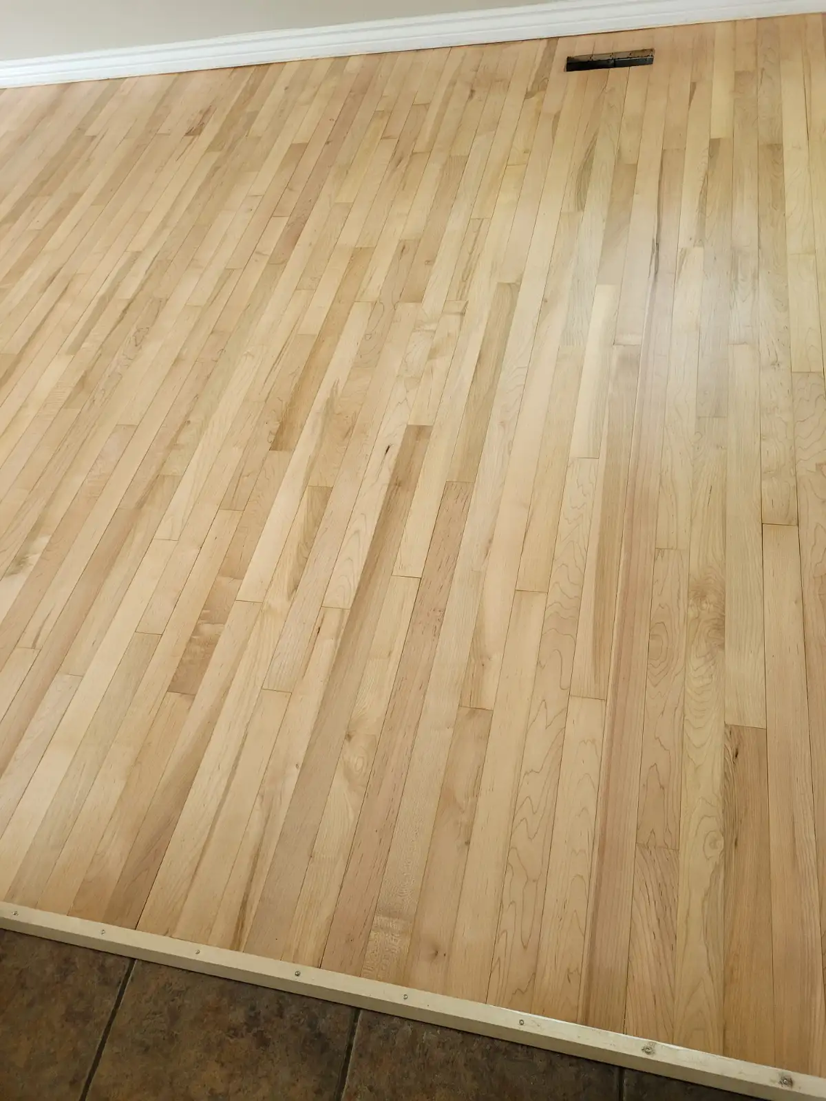 Maple floor sanded smooth against fresh white trim